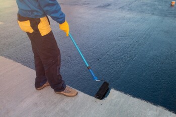 Roofer applying roof coating in Jacksonville, FL